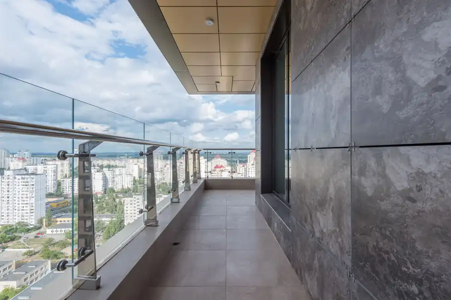 Balkon mit Glasgeländer und beschichtetem Boden